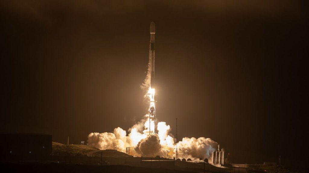 a black-and-white spacex falcon 9 rocket launches into a night sky.