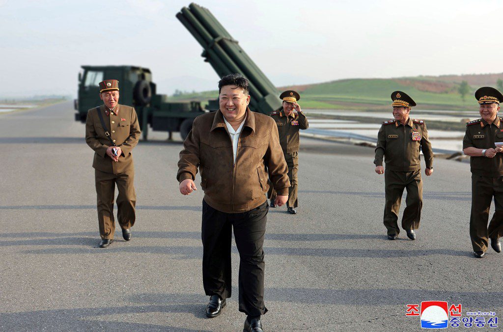 Il leader nordcoreano Kim Jong Un esce dal sito di lancio dei missili con quattro persone dietro di lui.