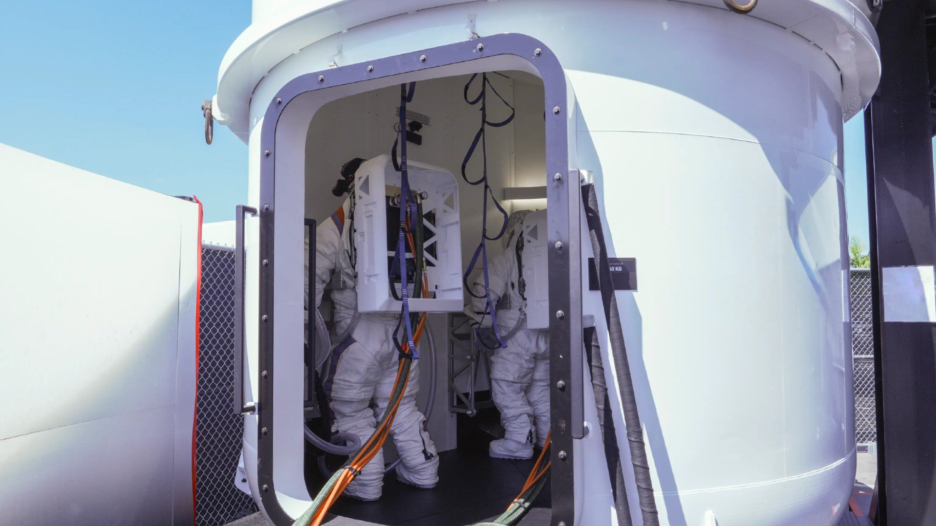 Gli astronauti in tute spaziali bianche si trovano all'interno di una camera di equilibrio bianca