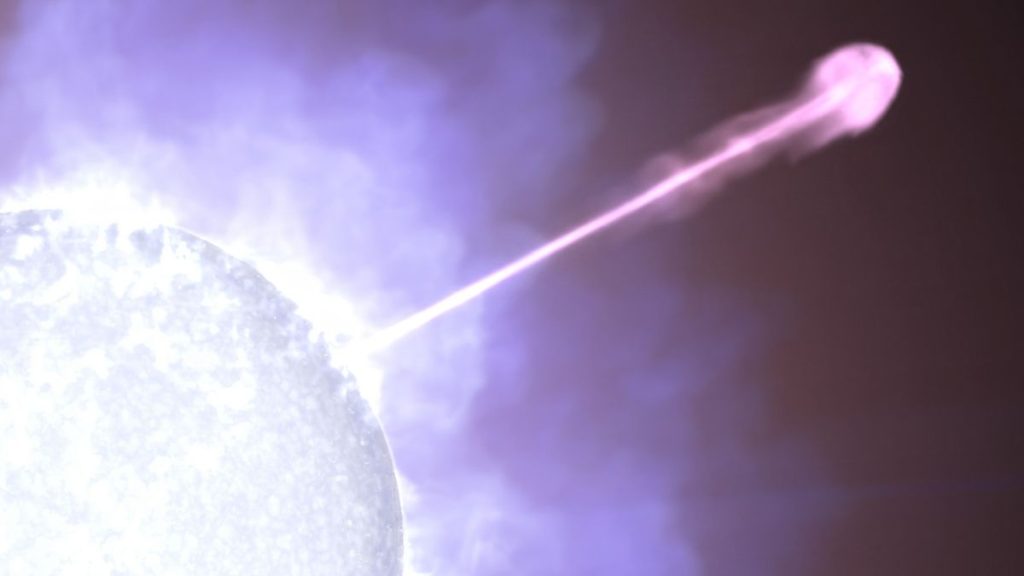 Against a cloudy white and purple background, part of a bright blue-white star is visible at lower left. Emerging from the star and stretching diagonally across the frame is a narrow line, looking white nearest the star and becoming magenta farther away. At far right, the line — one of the dying star’s particle jets — forms a large, rounded blob.