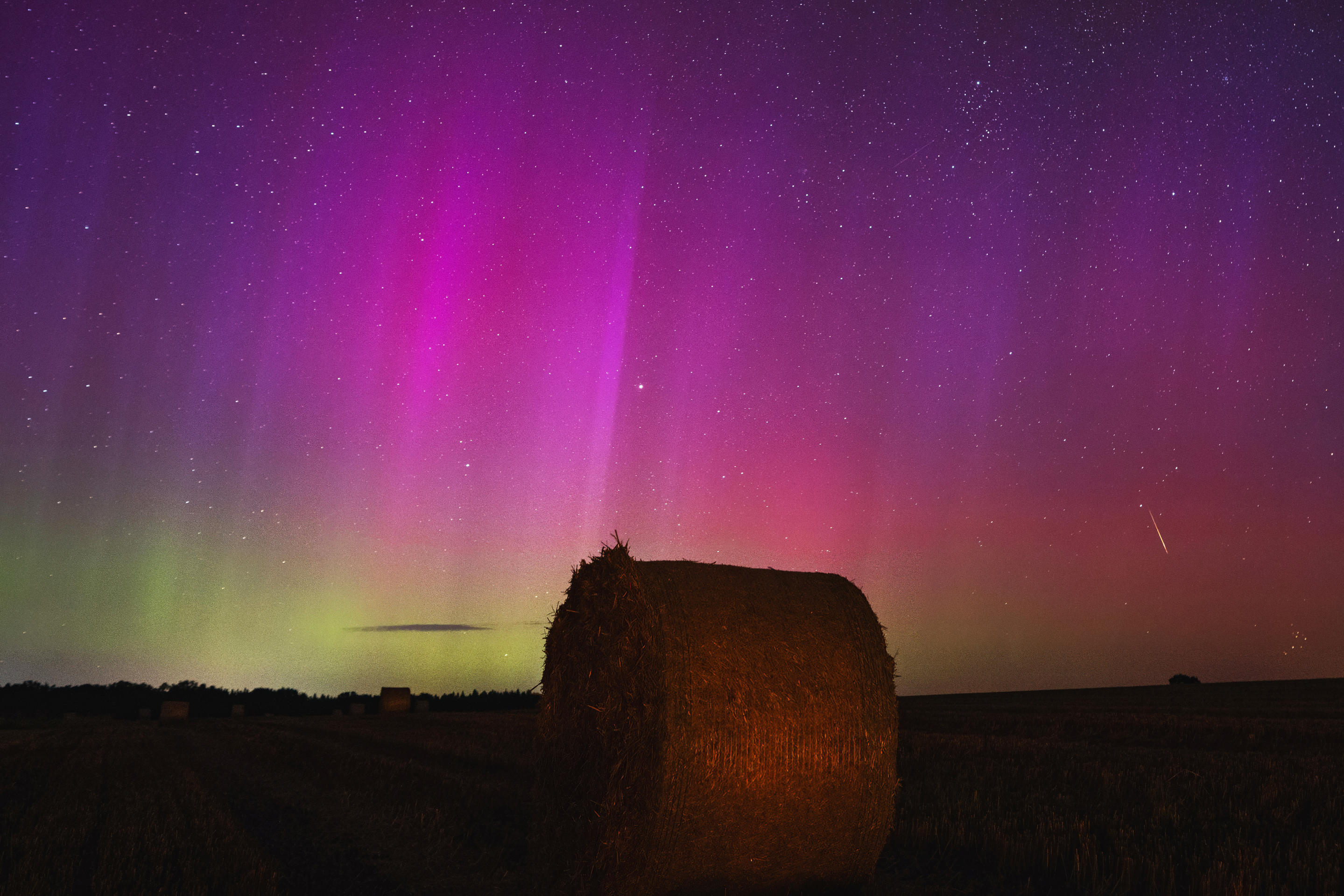 Uno spettacolo abbagliante dell'aurora boreale su un campo di fieno nel Brandeburgo, in Germania.