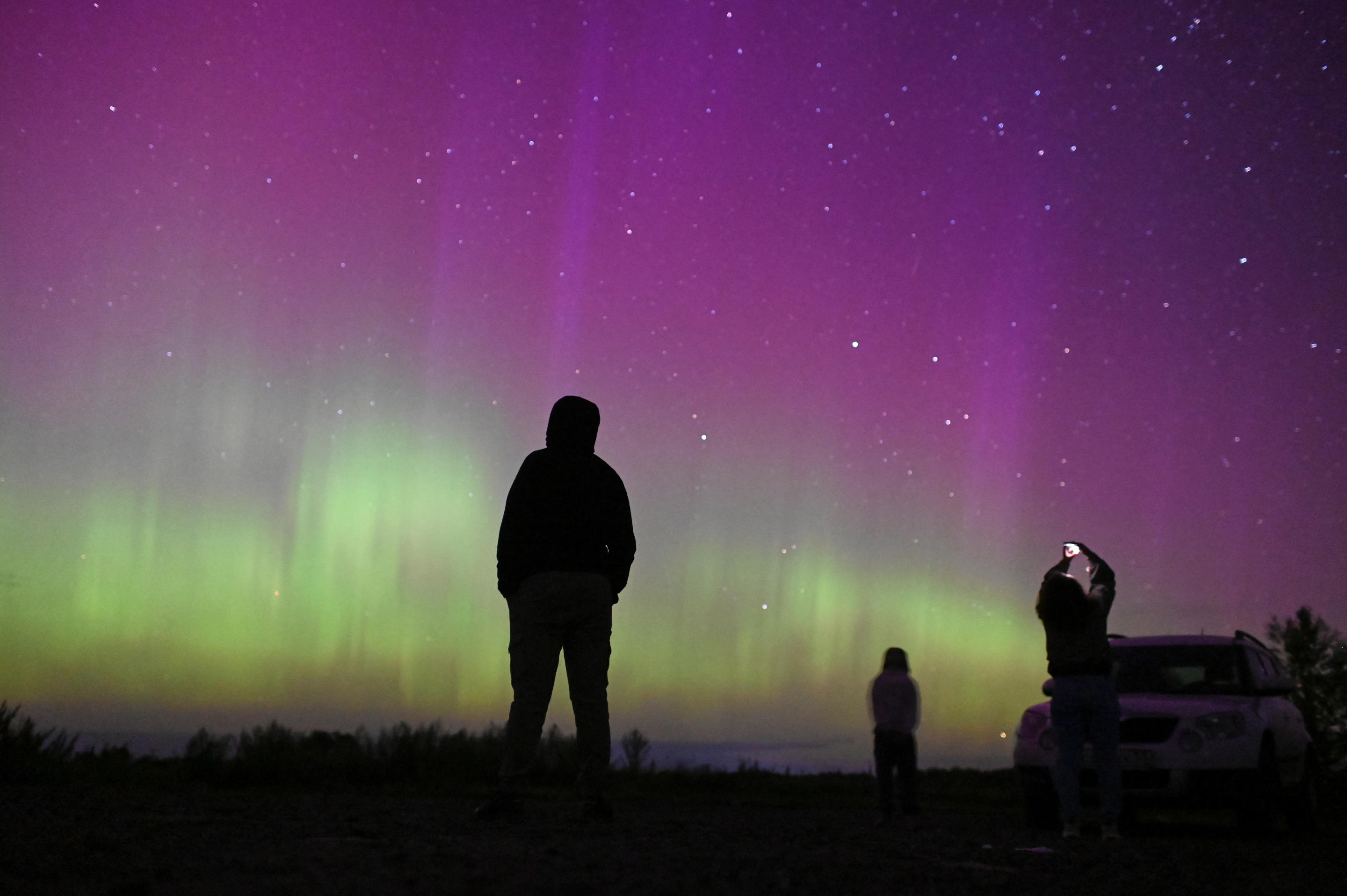 Le persone si riuniscono per assistere allo spettacolare spettacolo dell'annuale pioggia di meteoriti delle Perseidi e dell'aurora boreale vicino al villaggio di Borodinka, nella regione russa di Omsk.