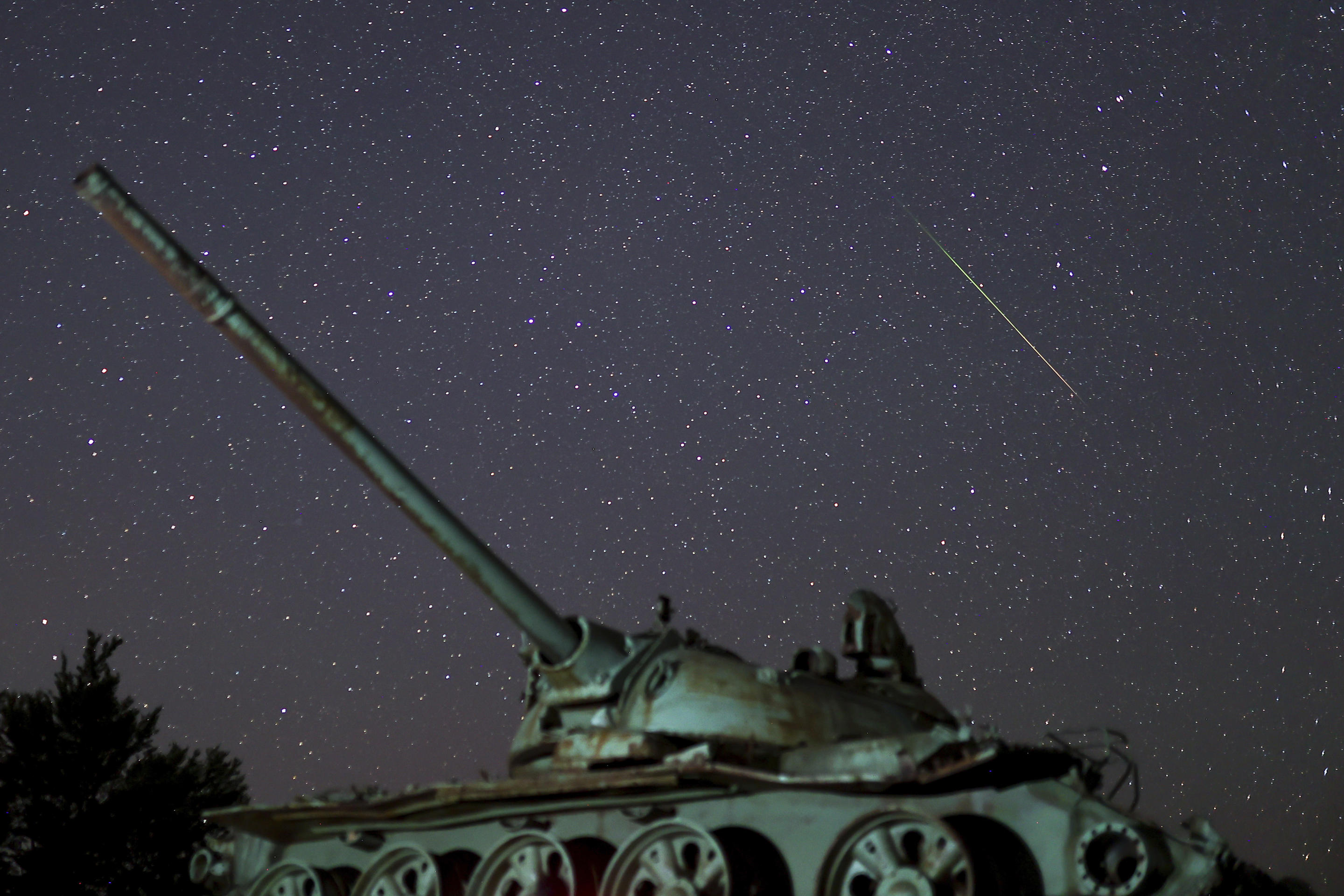 Una meteora attraversa il cielo sopra un carro armato distrutto, abbandonato sul monte Bjelasnica dopo la guerra in Bosnia. 