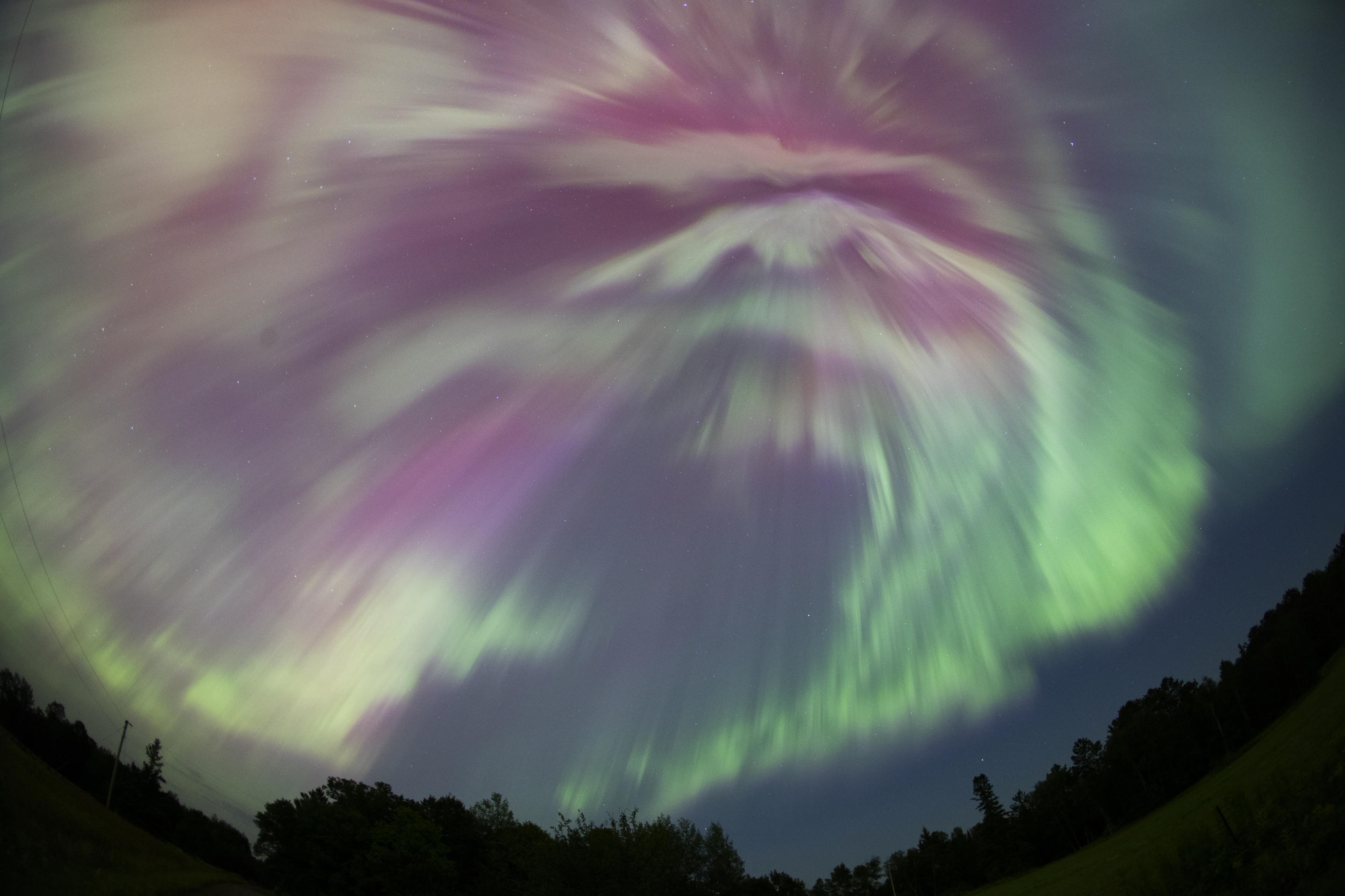 Una tempesta geomagnetica produce vivaci colori verdi e rosa durante il picco dello sciame meteorico delle Perseidi ad Aitkin, Minnesota.