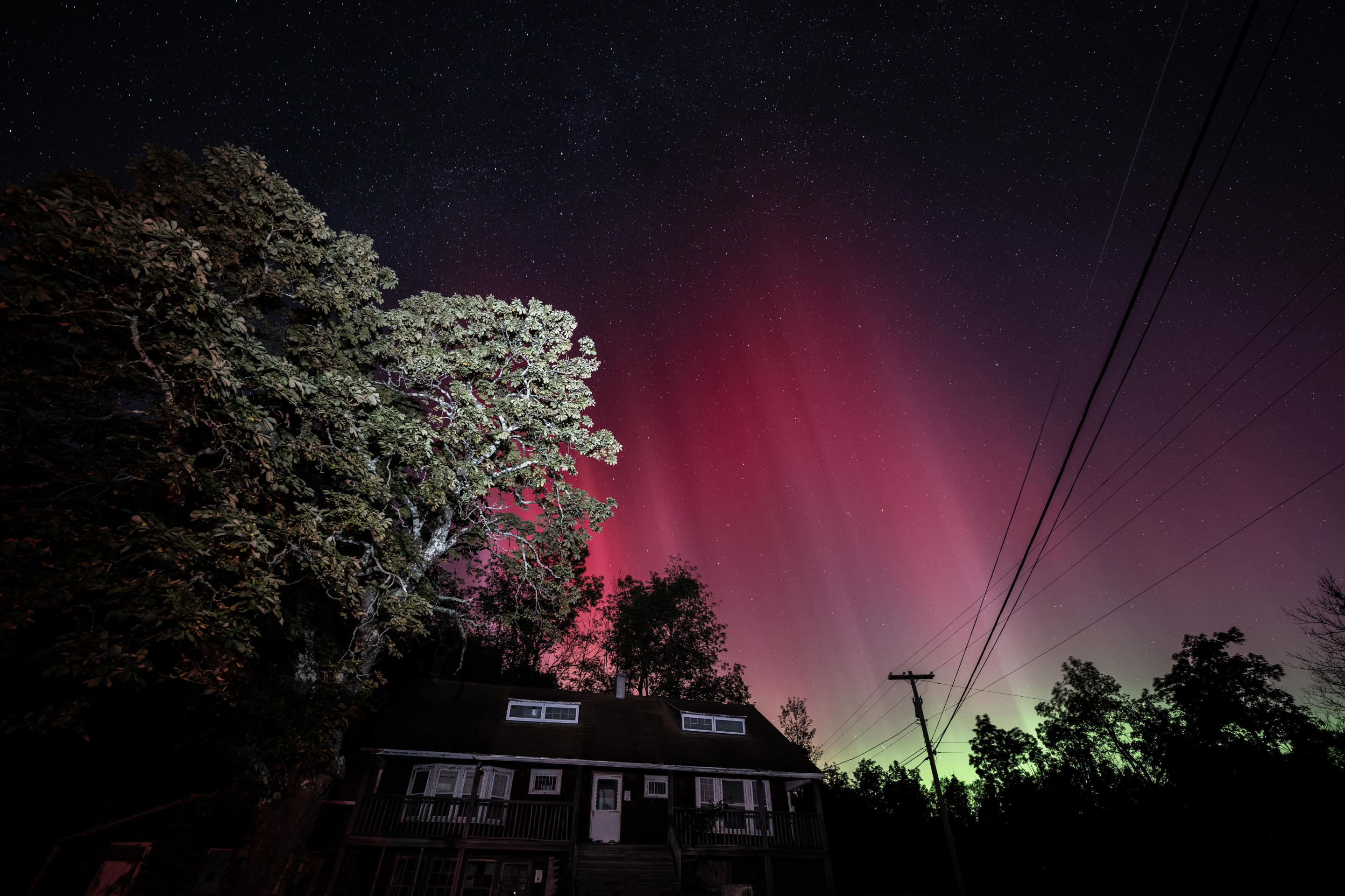 Un raro spettacolo colorato mentre l'aurora boreale illumina il cielo sopra una casa di New York.