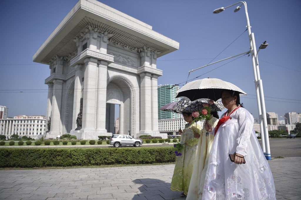 I pedoni camminano davanti all'Arco di Trionfo a Pyongyang il 15 agosto 2024, mentre la Corea del Nord celebra la 79a Giornata di Liberazione Nazionale, commemorando la fine del dominio coloniale giapponese alla fine della Seconda Guerra Mondiale.