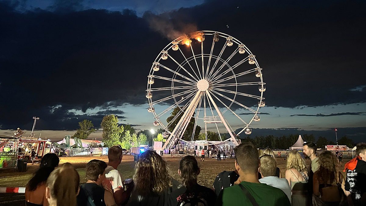 Gli spettatori guardano la ruota panoramica continuare a bruciare