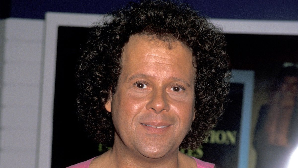 Richard Simmons indossa una maglietta rosa.